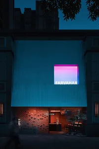 A modern building exterior at night with a large window and dramatic lighting