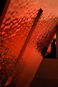 A modern interior space with orange and red glass walls, creating a striking contrast and a contemporary feel