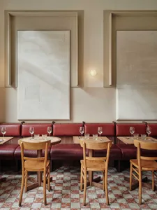 Empty restaurant interior with wooden tables and chairs, wine glasses, and a warm atmosphere