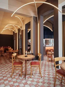 cozy restaurant interior with wooden floors, tables, chairs, and wine glasses