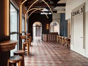 Inviting restaurant space with high ceilings, chairs, and a dining table, creating a comfortable atmosphere