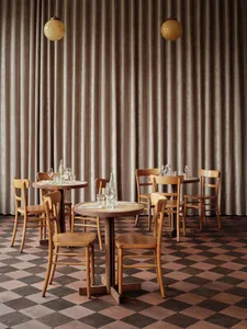 A dining area with several wooden chairs arranged around a table, set up for a meal in a warm and inviting atmosphere