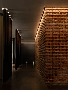 A dimly lit hallway with brick walls, two doors, and a rustic atmosphere