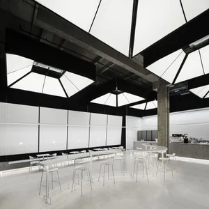 Modern restaurant interior with white walls, tiled and carpeted flooring, and multiple dining tables and chairs