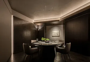 Dining area with a round table, chairs, and artwork on the walls, set in a well-lit modern home