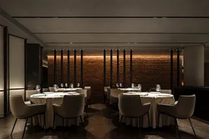 A restaurant with brick walls, multiple dining tables, and chairs, creating a welcoming atmosphere for guests