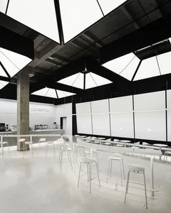 A bright and inviting dining space with a large white table surrounded by multiple chairs, creating a welcoming atmosphere