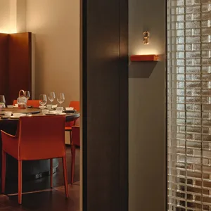 Dining area with a large wooden table surrounded by chairs, wine glasses, and a sophisticated atmosphere