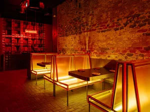 A warm and inviting restaurant interior with yellow chairs and metal tables, soft diffused lighting, and a cheerful atmosphere