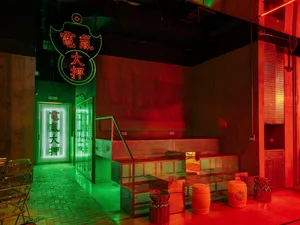 Vibrant Asian restaurant interior with red and green neon sign, tiled flooring, and modern-traditional decor