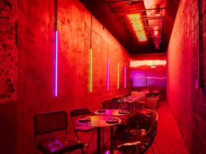 A warm and inviting dining area with several tables and chairs, suggesting a restaurant or large gathering space