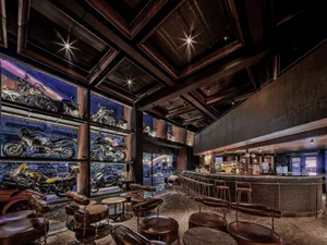 A casual bar with motorcycles on display, surrounded by chairs and a welcoming atmosphere