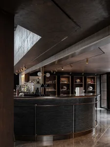 Cozy bar area with a wooden countertop, bottles, cups, wine glasses, and decorative vases