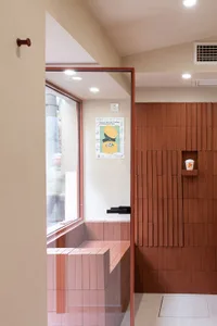 Cozy bathroom with a brick wall, a wooden bench, and two people in the scene