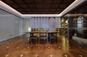 Elegant dining space with a large wooden table, marble top, and several chairs, set in a well-lit room with a modern yet classic design