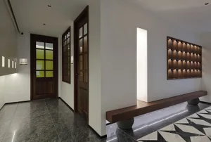 Cozy living space with a wooden bench in front of a doorway, surrounded by two doors and a warm atmosphere