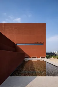 A modern building with a red brick exterior and a large window on its side