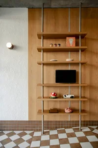 A wooden bookshelf filled with books, a TV, and decorative objects, creating a cozy and comfortable living space