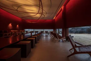 紅牆現代餐廳休閒區，設有餐桌、椅子、沙發，營造舒適親切的社交與用餐氛圍