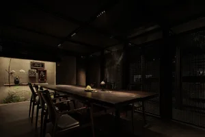 A formal dining area with a large wooden table surrounded by multiple chairs, set up for a meal in a warm and inviting environment
