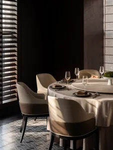 Elegant dining space with a round table, four chairs, and fine dinnerware, set for a formal gathering