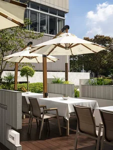 An outdoor dining area with tables covered in white tablecloths, chairs, and umbrellas, creating a comfortable seating arrangement for guests