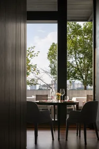 A warm and inviting dining area with a table surrounded by chairs, wine glasses, and a cozy atmosphere