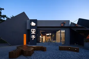 A modern Asian restaurant with a large dining area, tables, chairs, and potted plants, creating an inviting and comfortable atmosphere