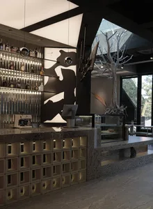 A casual bar area with a counter featuring a coffee maker and TV, surrounded by bottles and chairs for seating