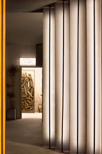 Traditional hallway with wooden surfaces, two potted plants, and a doorway leading to another room