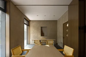 A modern dining area with a wooden table and chairs, surrounded by a clean and minimalist space