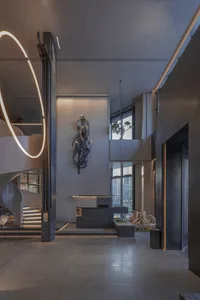 Open modern living space with natural light, staircases, a countertop, sink, and potted plants