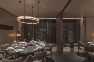 Sophisticated restaurant interior with a large dining table, wooden walls, and wine glasses