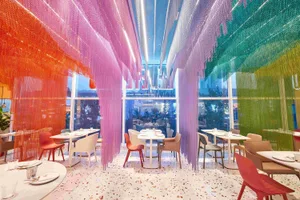 A well-lit restaurant dining area with multiple tables and chairs, inviting atmosphere, and stylish environment