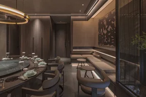 A warm and inviting dining space with a round table set for guests, surrounded by chairs and creating a cozy atmosphere