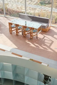 A modern dining area with a glass table surrounded by metal-framed chairs, set in a well-lit space