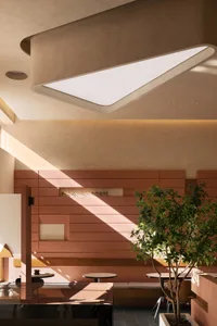 A hotel lobby with wooden walls and ceilings, featuring two potted plants and a clock on the wall, creating a warm and inviting atmosphere