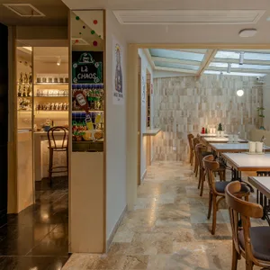 Dining area with multiple tables and chairs, wood paneling, and tiled surfaces, creating a warm and inviting atmosphere