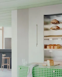 Cozy kitchen scene with a wall-mounted oven, wooden furniture, and a warm atmosphere