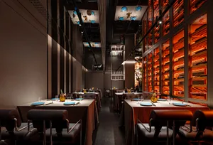 Modern restaurant with dining tables, chairs, and contemporary design elements, featuring warm and inviting lighting