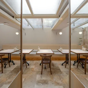 A modern restaurant interior with multiple tables and chairs, providing a comfortable atmosphere for guests to enjoy their meals