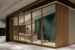 明亮溫馨的商店內部，充滿自然光線、兩株盆栽與大片窗戶