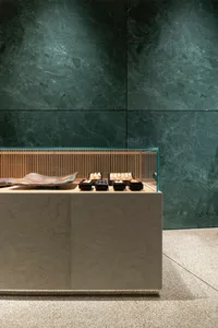 A glass display case in a store showcases neatly arranged cakes, donuts, and pastries, creating an inviting atmosphere