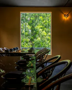 Bright and inviting dining area with a large window, chairs, and a dining table with various items