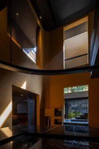 Open living area with yellow walls, wooden floors, natural light, and a staircase, featuring a couch, TV, and potted plant
