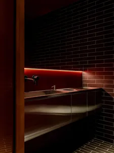 Bathroom with a sink under a red wall, well-lit and inviting