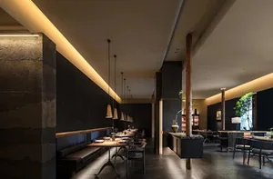 Warm and inviting restaurant interior with dining tables, chairs, and potted plants