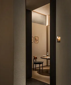 A modern dining area with a concrete finish, featuring a table and two chairs in a dimly lit space