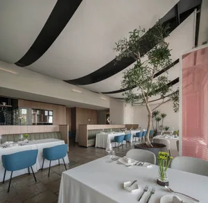 Elegant indoor dining space with a large dining table, multiple chairs, and potted plants