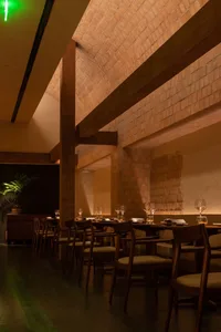 Warm and inviting restaurant with wooden tables and chairs, wine glasses, and a focus on comfortable dining